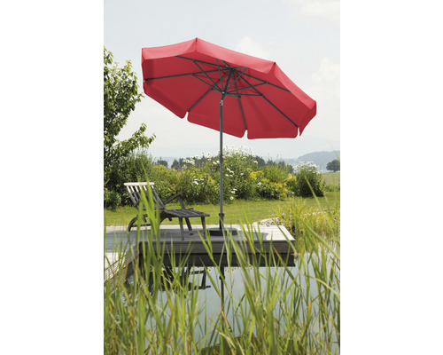 Rode parasol naast een ligstoel in de tuin