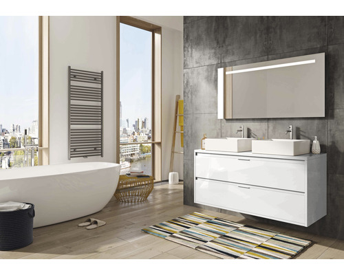 Lichte badkamer met ligbad, handdoekradiator, wastafelmeubel met twee wastafels en verlichte spiegel.