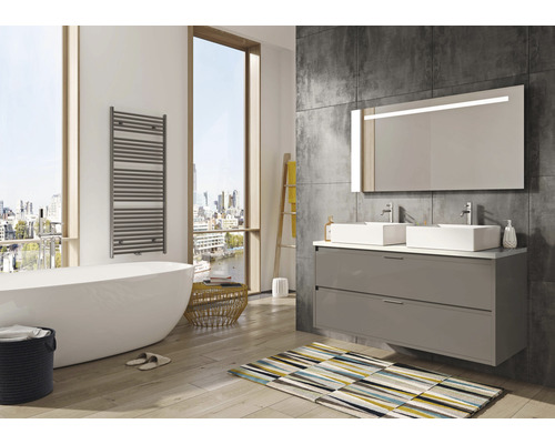 Moderne badkamer met ligbad, wastafelmeubel met twee wastafels en verlichte spiegel.