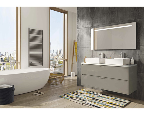 Lichte badkamer met bad, wastafelmeubel met spiegel en handdoekradiator