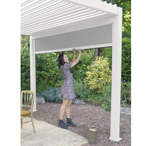 Vrouw bedient een pergola met uitschuifbare zonwering voor de tuin.