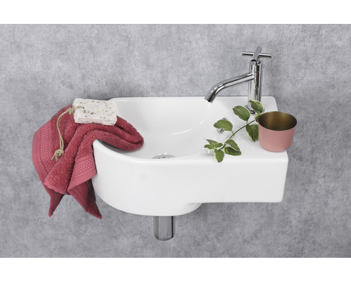 Foto van een wastafel met kraan, handdoek, zeep en decoratie