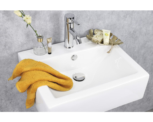 Wastafel met kraan, handdoek en decoratieve artikelen