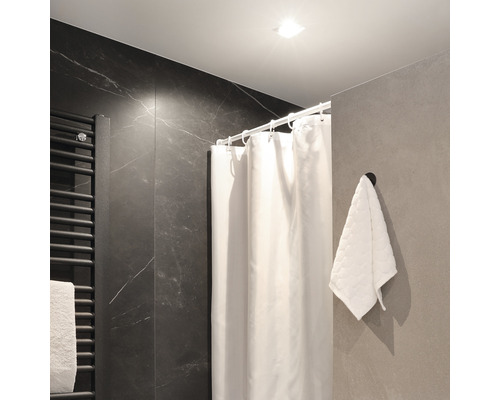 Badkamer met douchegordijn, handdoek en handdoekradiator