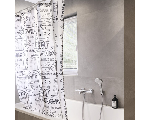 Badkamer met ligbad en douchegordijn met grafisch patroon