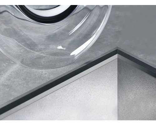 Detailopname van een douchegoot naast een transparant glazen object