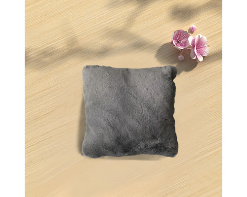 Grijs kussen op een houten tafel met bloemen