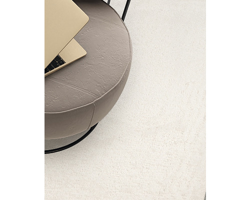 Hoogpolig tapijt naast een bijzettafel met laptop