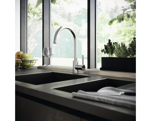 Keukenscène met spoelbakmengkraan, gootsteen, fruit en kruiden voor een raam