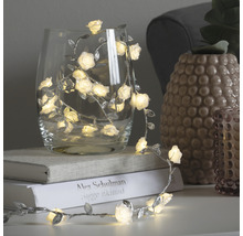 Decoratieve lichtslinger met rozen en bladeren in een glas