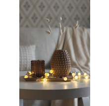 Decoratie met vaas, theelichthouder en lichtslinger op een tafel