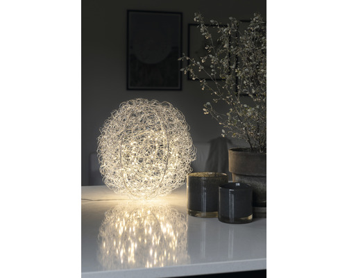 Decoratieve bolvormige tafellamp met draadgaas en ledlampjes op een tafel