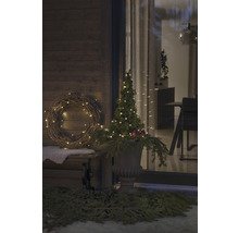 Gedecoreerde veranda met verlichte krans en boom in vaas