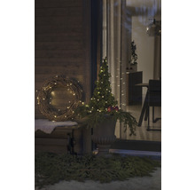 Gedecoreerde veranda met krans, verlichte boom en plantenbak