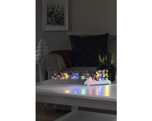 Decoratief winterarrangement met verlichte hondenslee op een tafel