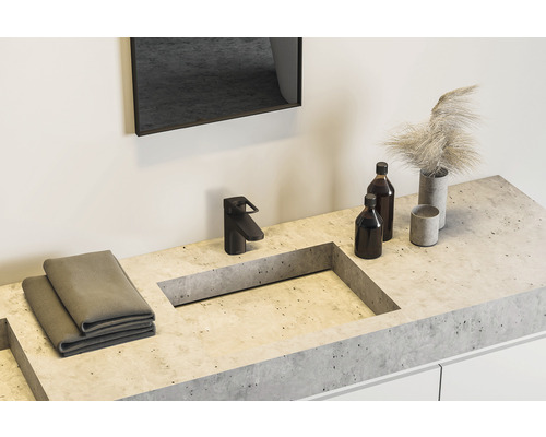 Badkamer wastafel met kraan, handdoeken, flessen en decoratie