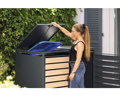 Vrouw opent afvalcontainerbox met een blauwe afvalbak