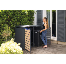 Afvalcontainerbox in de tuin met een vrouw die een afvalcontainer plaatst