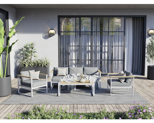 Terras met zitgroep bestaande uit bank, fauteuils en tafel op een tapijt