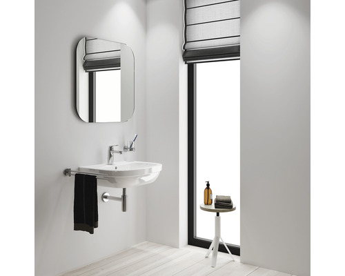 Badkamer met wastafel, spiegel en raam met rolgordijn