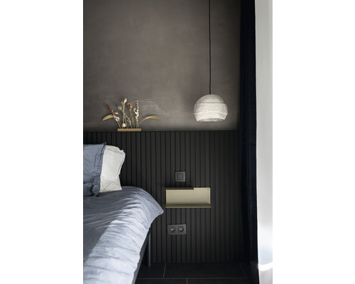 Slaapkamer met bed, lamp en wandplank