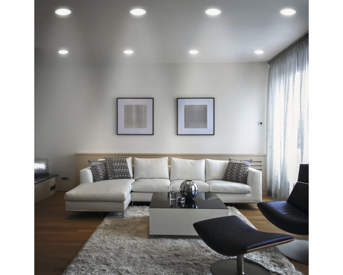 Woonkamer met plafondlampen, bank, vloerkleed en decoratie