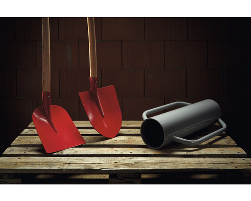 Twee spades met houten steel en een grondboor op een pallet.