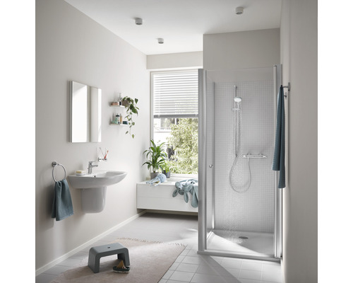 Lichte badkamer met douche, wastafel en raam