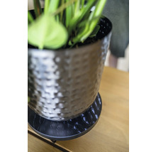 Decoratieve bloempot met schotel op een tafel