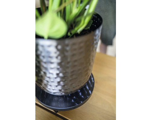 Decoratieve bloempot met schotel op een tafel