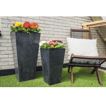 Twee plantenbakken met bloemen en een houten stoel met kussen op kunstgras