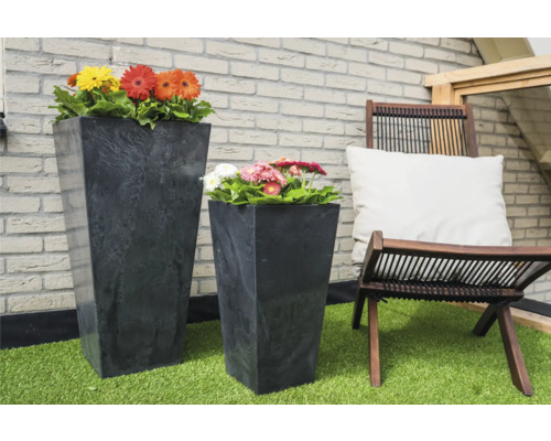 Scene met twee plantenbakken, beplant met gerbera''s en een houten stoel met kussen op een terras.