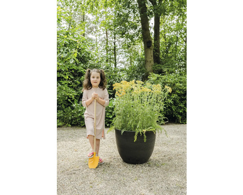 Meisje met schep en plantenbak in de tuin