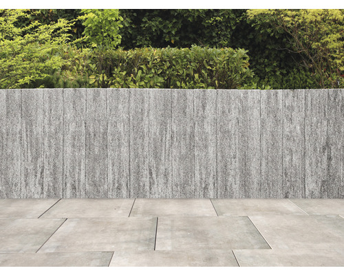 Tuin met stenen muur en bestrating