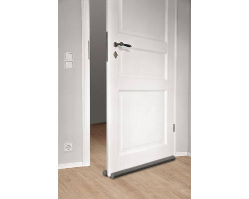 Open witte deur met tochtstopper op de vloer
