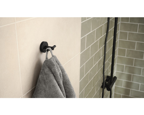 Dubbele haak met handdoek aan de muur in de badkamer