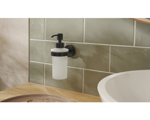 Wandzeepdispenser van glas en metaal in de badkamer