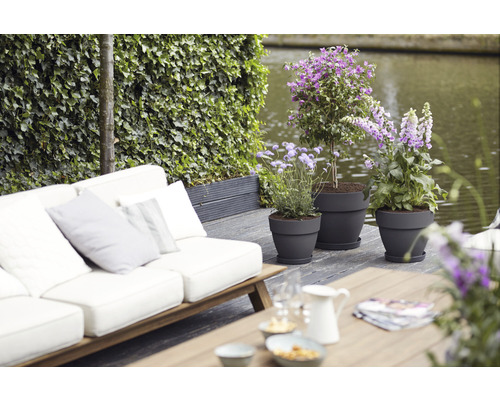 Scene met tuinmeubelen en beplante bloempotten op een terras