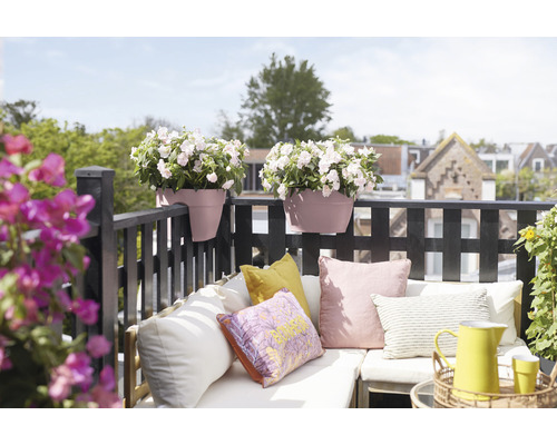 Gedecoreerde balkonscène met bloembakken, kussens en zitplaatsen