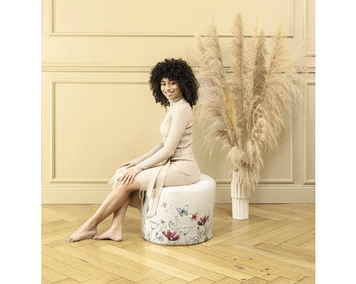 Vrouw zit op een ronde kruk met bloemmotief