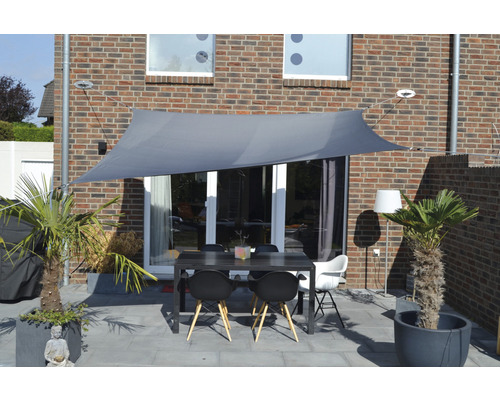 Terras met schaduwdoek, eettafel en planten