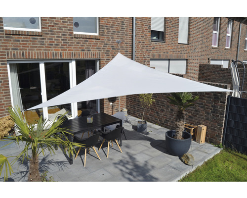 Terras met zonnescherm, tafel en stoelen voor stenen huis