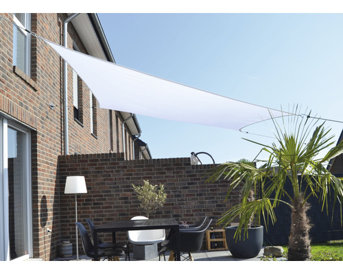 Terras met zonnescherm, tafel en stoelen voor een bakstenen gebouw