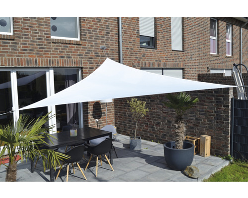 Buitenzitgedeelte met zonnescherm, tafel en stoelen voor een bakstenen huis