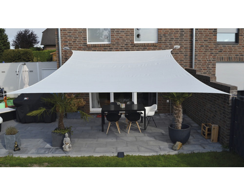 Rechthoekig zonnescherm van stof boven een terras met tafel en stoelen