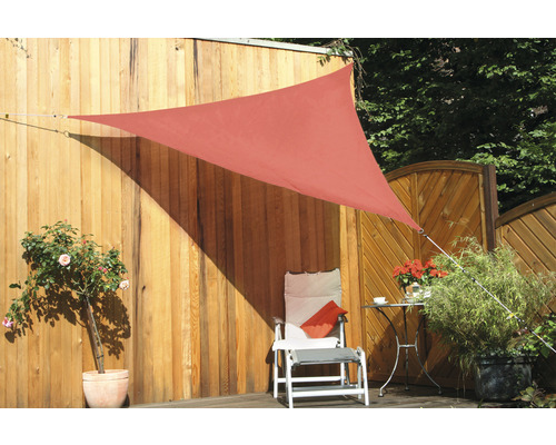 Driehoekig zonnescherm in de tuin met stoel en planten