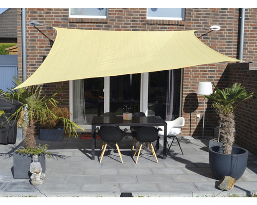 Terras met zonnescherm, tafel en stoelen voor een bakstenen gebouw