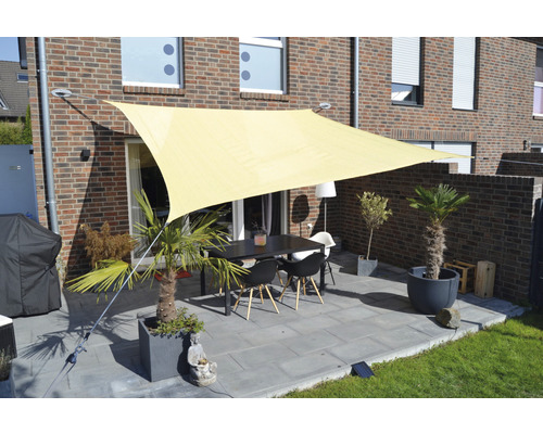 Terras met zonnescherm, tafel en stoelen voor een bakstenen huis