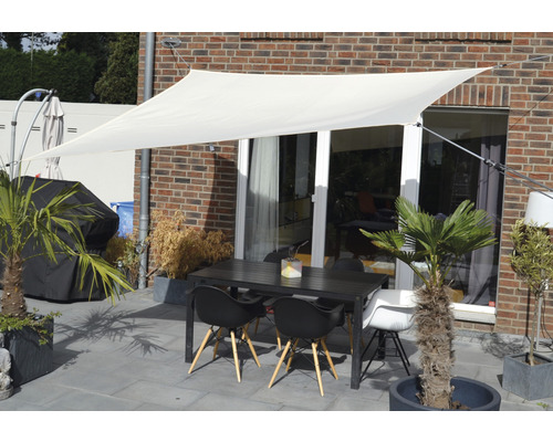 Terras met zonnescherm, tuintafel en stoelen voor een huiswand