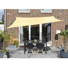 Buitenruimte met zonnescherm, tafel en stoelen op een terras voor een huis.